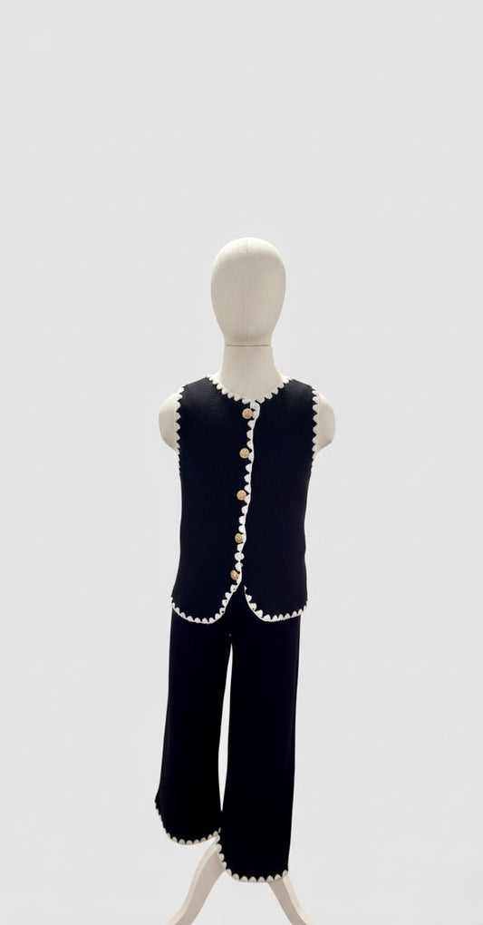 Ensemble deux pièces noir avec détails ondulés et boutons dorés